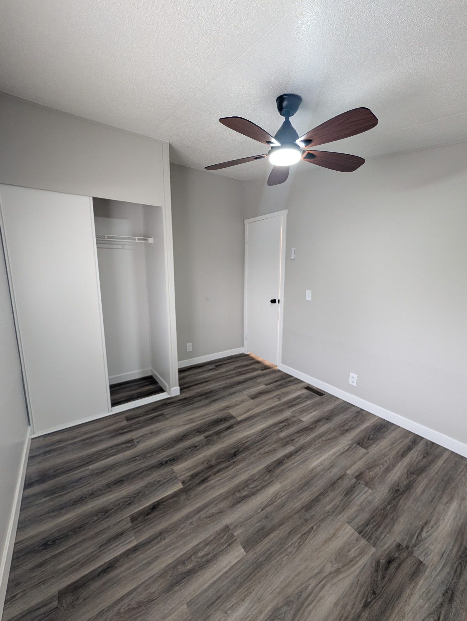 Bedroom with hardwood floor, closet, and fresh paint in Utah
