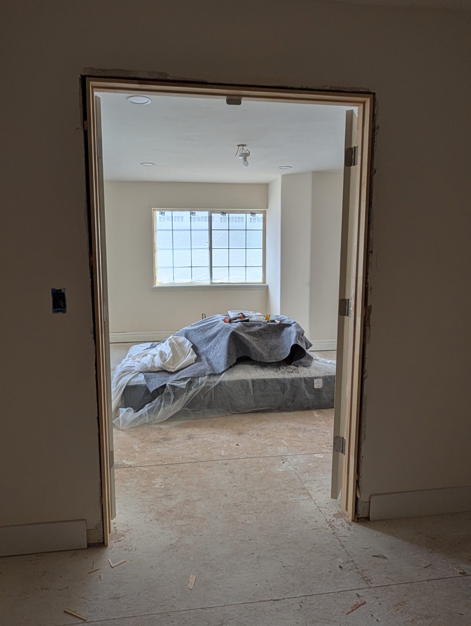 Interior bedroom prepped with drop cloths for painting in Utah